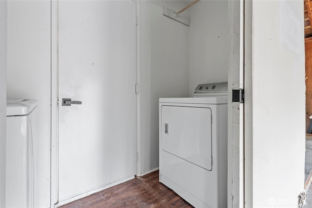 laundry room with dark wood-style floors, separate washer and dryer, and laundry area