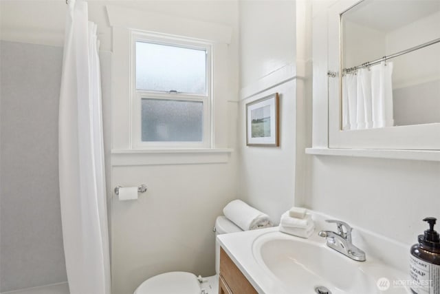 bathroom featuring vanity, toilet, and curtained shower