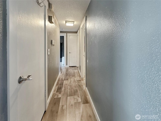 14914 20th Ave E, Parkland, WA 98445 - corridor featuring a textured ceiling, baseboards, and wood finished floors