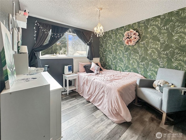 14914 20th Ave E, Parkland, WA 98445 - bedroom featuring a textured ceiling, wallpapered walls, an accent wall, and wood finished floors