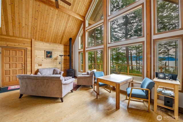 sunroom / solarium with a wood stove and beamed ceiling