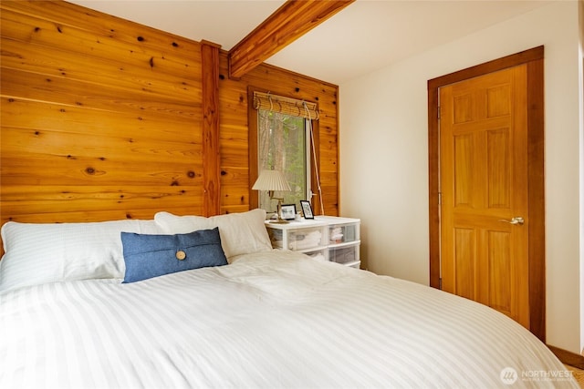 bedroom with wooden walls and beamed ceiling