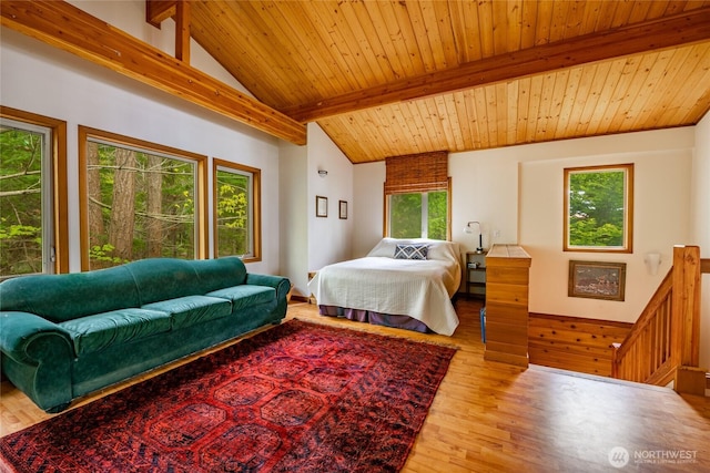 bedroom with lofted ceiling with beams, wood finished floors, and wooden ceiling