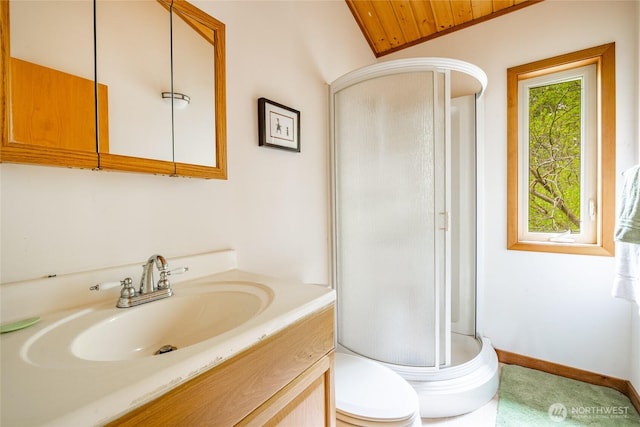 full bathroom featuring vanity, baseboards, a stall shower, and toilet