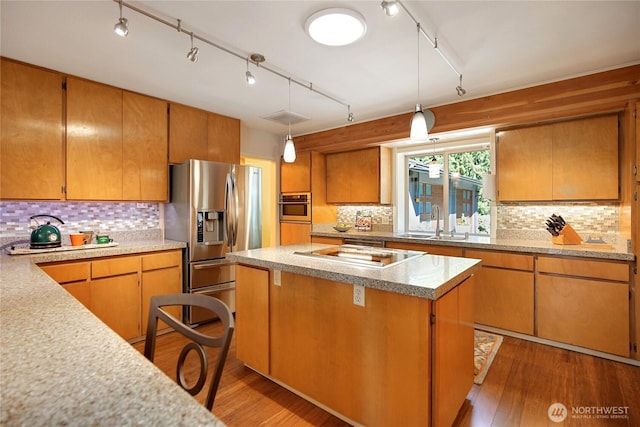 kitchen with light countertops, track lighting, appliances with stainless steel finishes, and a sink