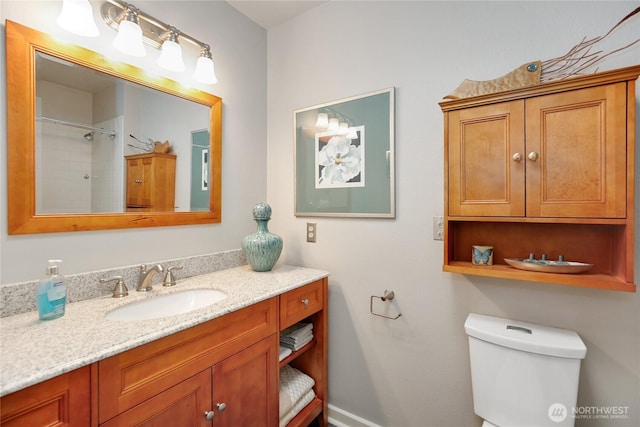 bathroom with toilet, vanity, and a shower