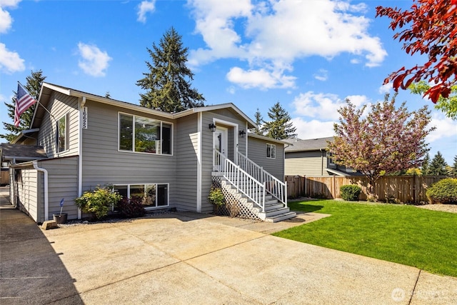 view of front facade with fence, a patio area, entry steps, and a front yard