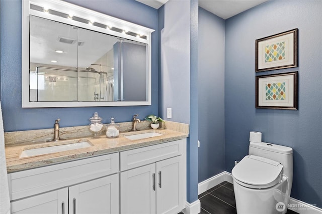 bathroom with tile patterned flooring, toilet, a sink, and a stall shower