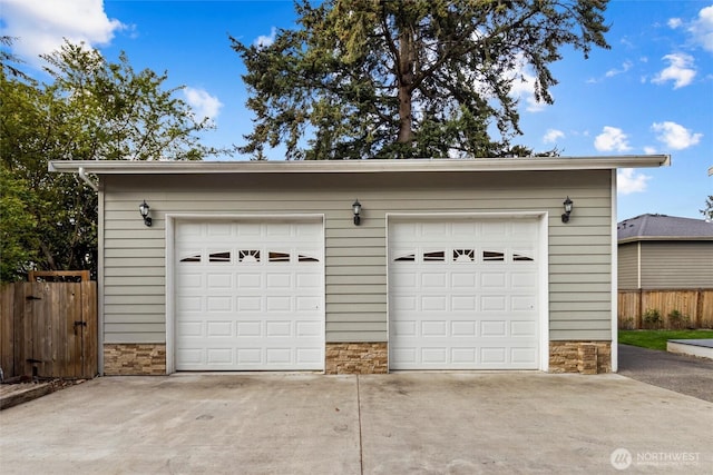 detached garage featuring fence