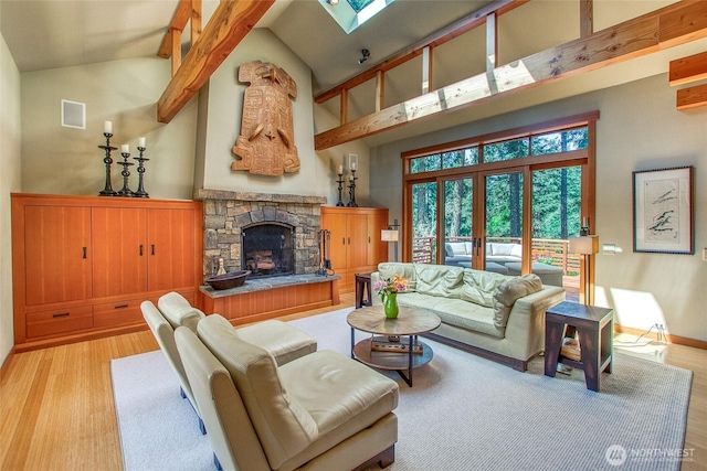 72 Thunderbird Trl, Orcas Island, WA 98280 - living area with light wood-style floors, high vaulted ceiling, a skylight, a fireplace, and baseboards