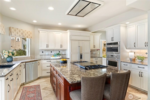 kitchen with decorative backsplash, a kitchen island, recessed lighting, a sink, and appliances with stainless steel finishes