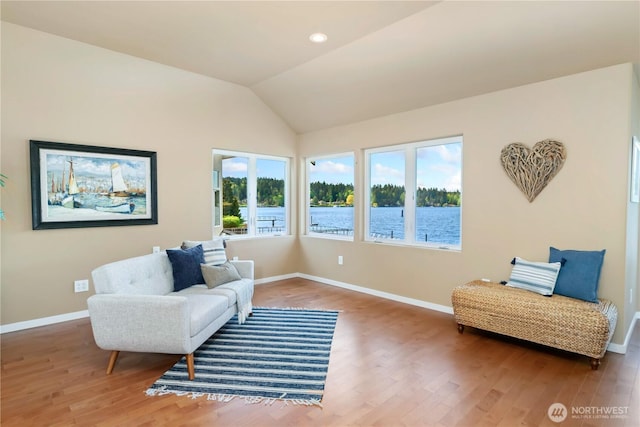 sitting room featuring baseboards, wood finished floors, and vaulted ceiling