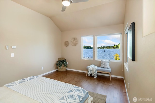 bedroom featuring wood finished floors, lofted ceiling, baseboards, ceiling fan, and a water view