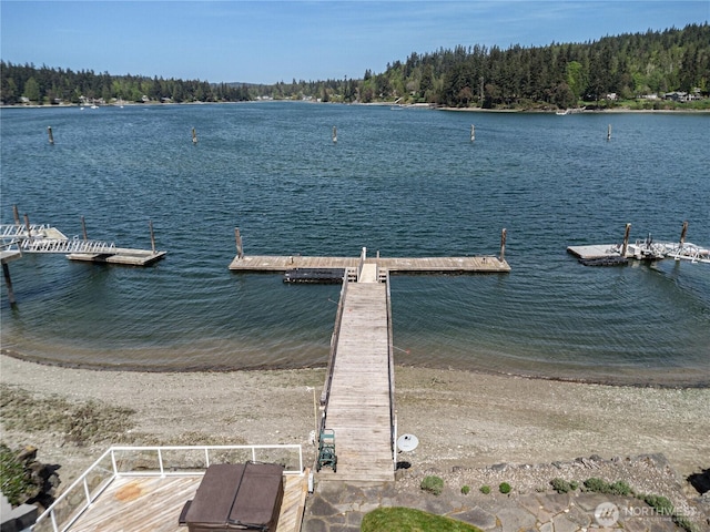 view of dock featuring a water view and a wooded view