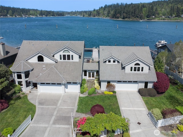 bird's eye view with a water view and a wooded view