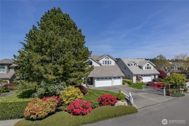 view of front of home with a tiled roof, a garage, a residential view, and aphalt driveway