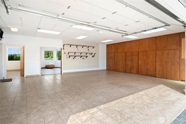 garage featuring baseboards and wood walls