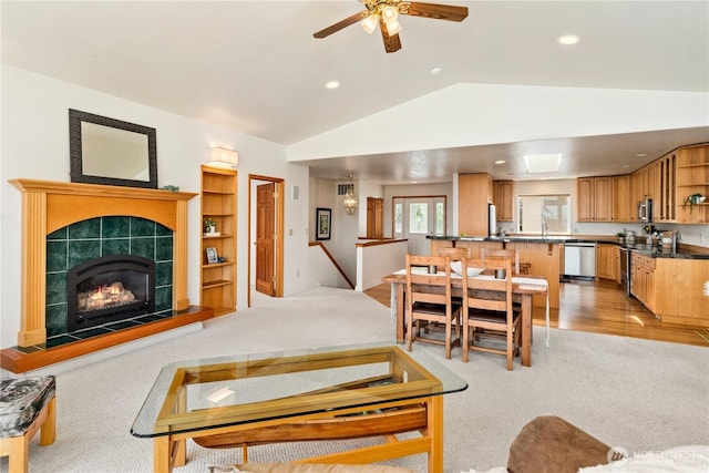 living room with light colored carpet, vaulted ceiling, recessed lighting, a ceiling fan, and a fireplace