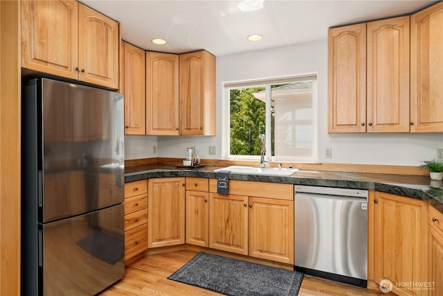 kitchen with stainless steel appliances, light wood-type flooring, recessed lighting, a sink, and tile counters