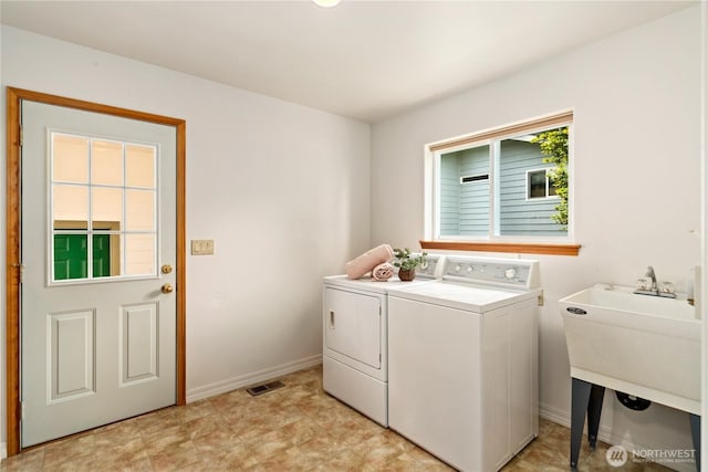 laundry area with washing machine and dryer and baseboards