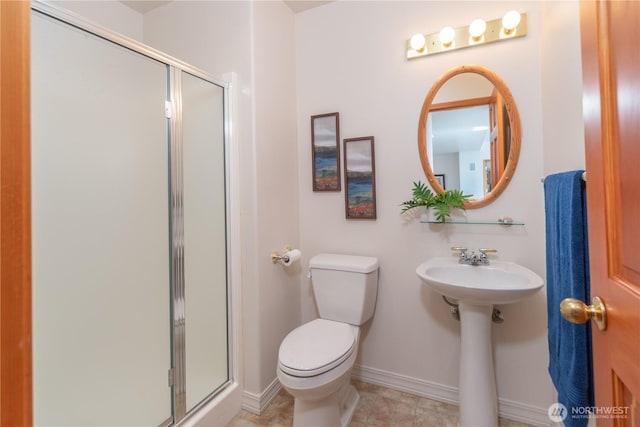 full bathroom with a shower stall, toilet, baseboards, and a sink
