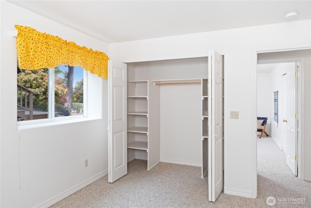 unfurnished bedroom with carpet floors, a closet, and baseboards