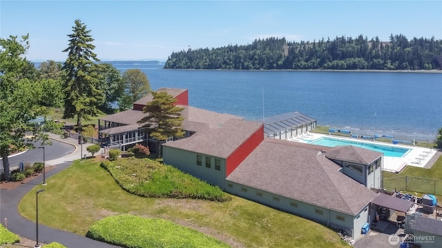 aerial view of a large body of water, a pool area, and a heavily wooded area