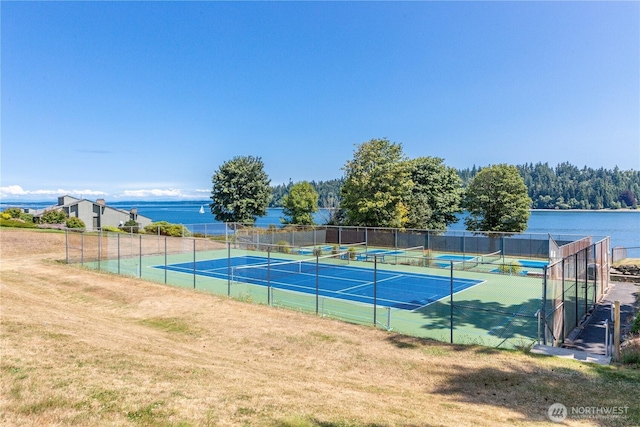 view of tennis court featuring a water view