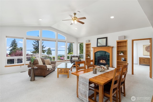 living area featuring a tile fireplace, light carpet, a ceiling fan, vaulted ceiling, and recessed lighting