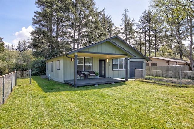 554 Puffin Ave NE, Ocean Shores, WA 98569 - rear view of property featuring a fenced backyard, an attached garage, a yard, and board and batten siding