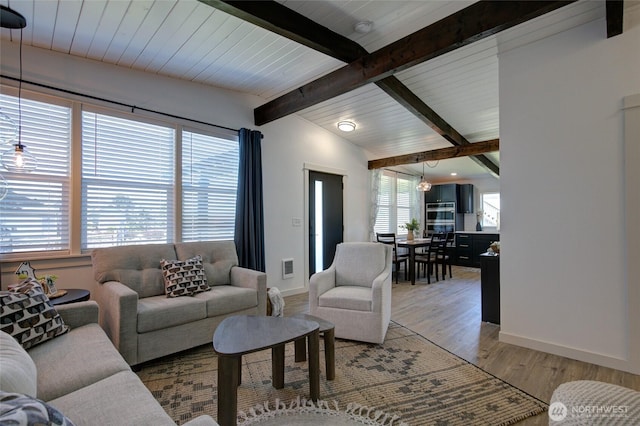554 Puffin Ave NE, Ocean Shores, WA 98569 - living area featuring light wood-style flooring, baseboards, visible vents, and vaulted ceiling with beams