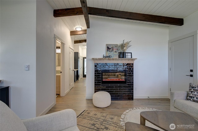 554 Puffin Ave NE, Ocean Shores, WA 98569 - living area with beam ceiling, a fireplace, light wood finished floors, wooden ceiling, and baseboards