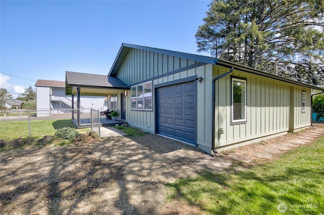 554 Puffin Ave NE, Ocean Shores, WA 98569 - view of side of home featuring board and batten siding, fence, a garage, and a carport