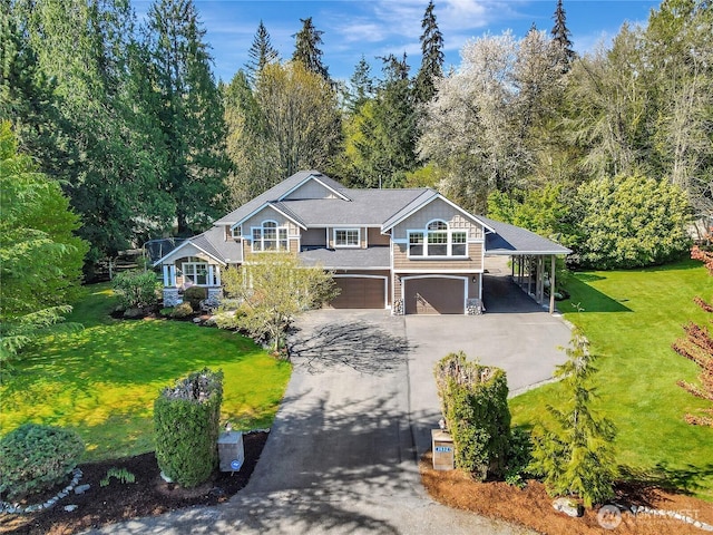 view of front facade featuring an attached garage, a front lawn, aphalt driveway, and a carport