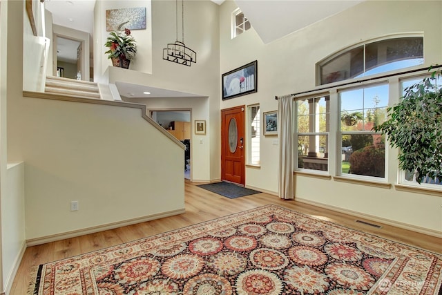 entrance foyer featuring baseboards, light wood-style flooring, visible vents, and a healthy amount of sunlight