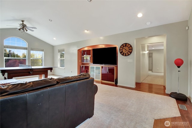 living area featuring ceiling fan, vaulted ceiling, a healthy amount of sunlight, and wood finished floors