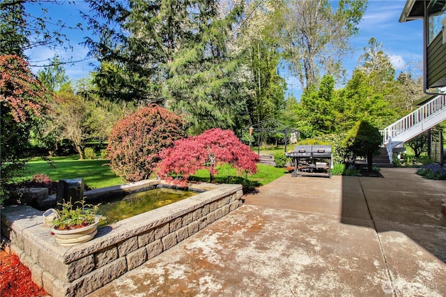 view of patio / terrace featuring concrete driveway and stairs