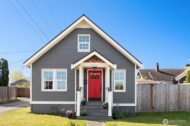 bungalow-style house with fence and a front yard