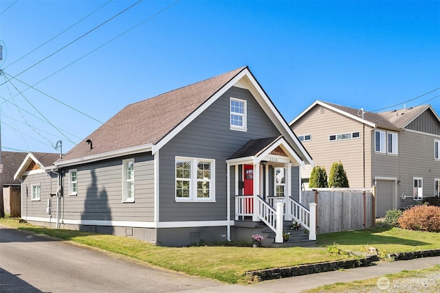 bungalow-style house featuring fence, roof with shingles, a front lawn, and crawl space