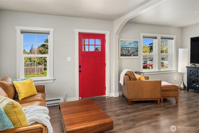 entryway with arched walkways, baseboards, a baseboard heating unit, and wood finished floors