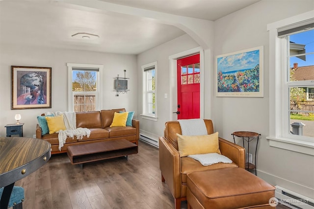 living area featuring arched walkways, a baseboard heating unit, dark wood-style floors, and a baseboard radiator
