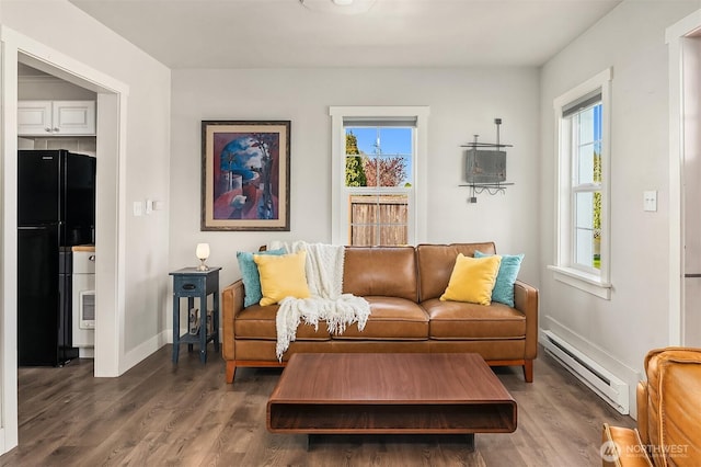 sitting room with baseboards, a baseboard radiator, and wood finished floors