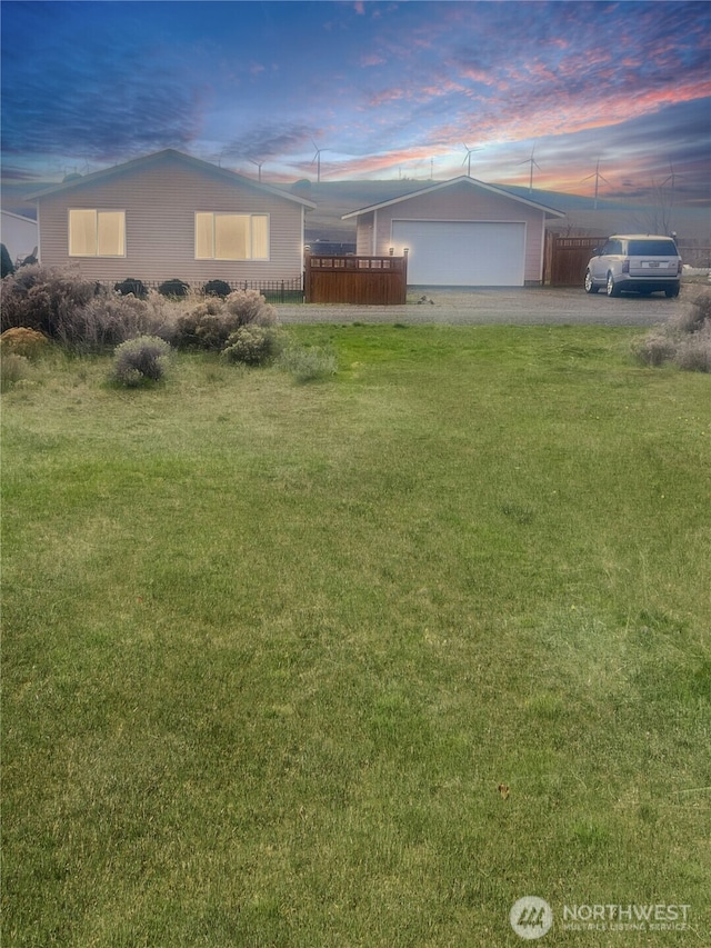 view of front of home featuring an attached garage, an outdoor structure, a front lawn, and aphalt driveway