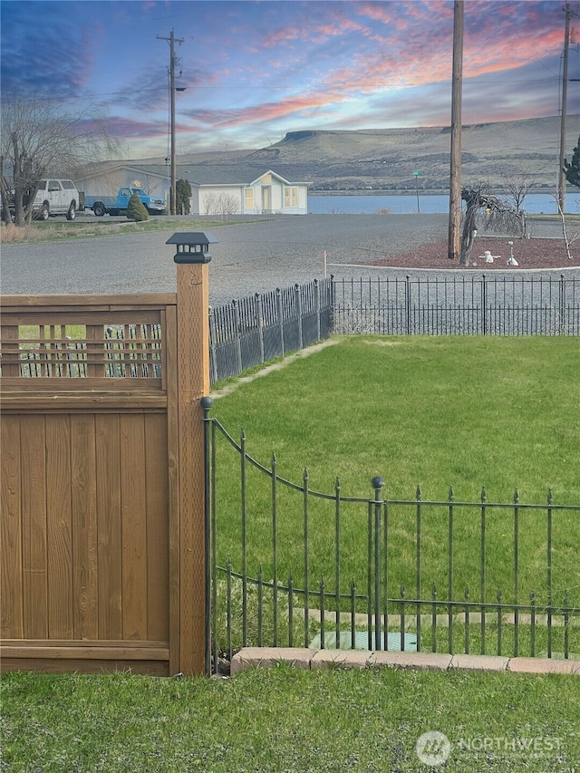 view of yard with a water view and fence