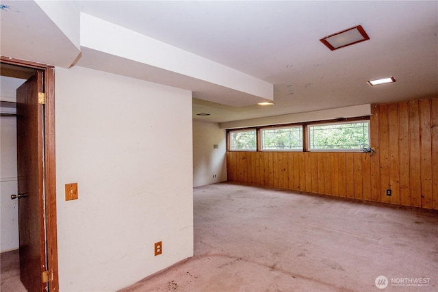 unfurnished room featuring wooden walls