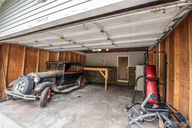 garage with wooden walls and a garage door opener
