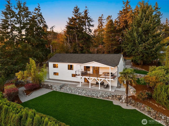 11016 46th St E, Edgewood, WA 98372 - back of house at dusk featuring a wooden deck, a lawn, a patio area, and stairs