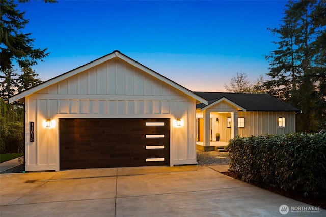 11016 46th St E, Edgewood, WA 98372 - view of front facade featuring board and batten siding, concrete driveway, an attached garage, and an outbuilding