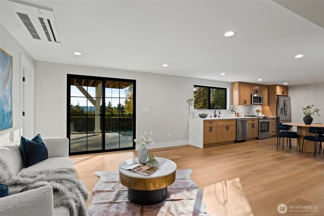 11016 46th St E, Edgewood, WA 98372 - living area featuring light wood finished floors, recessed lighting, healthy amount of natural light, and baseboards