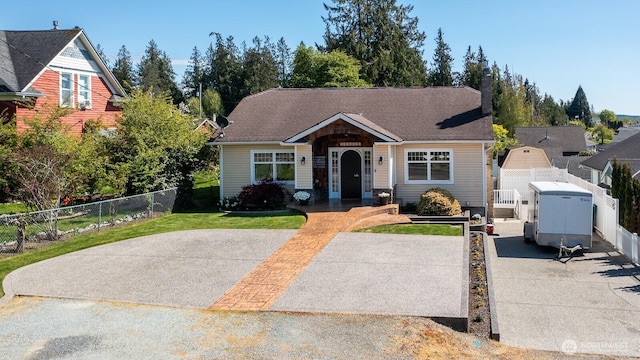 bungalow-style home with fence and a front lawn